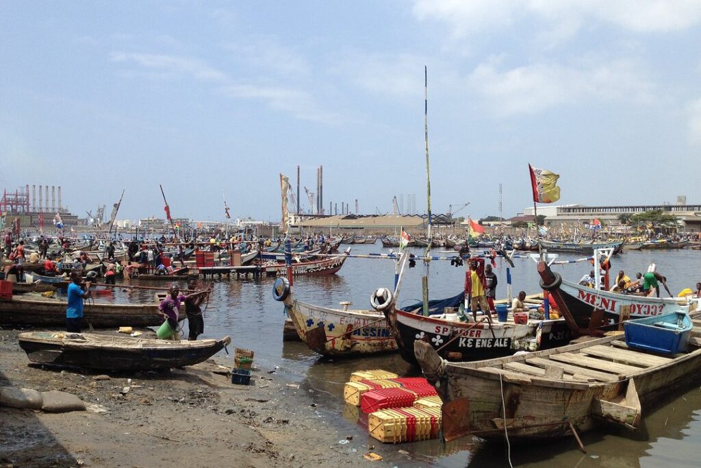 Traditional fishing boats crowded in a coastal harbour in Ghana