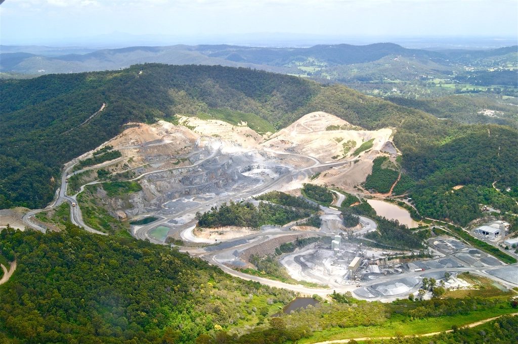 Aerial view of an open-pit mine with terraced extraction benches and haul roads