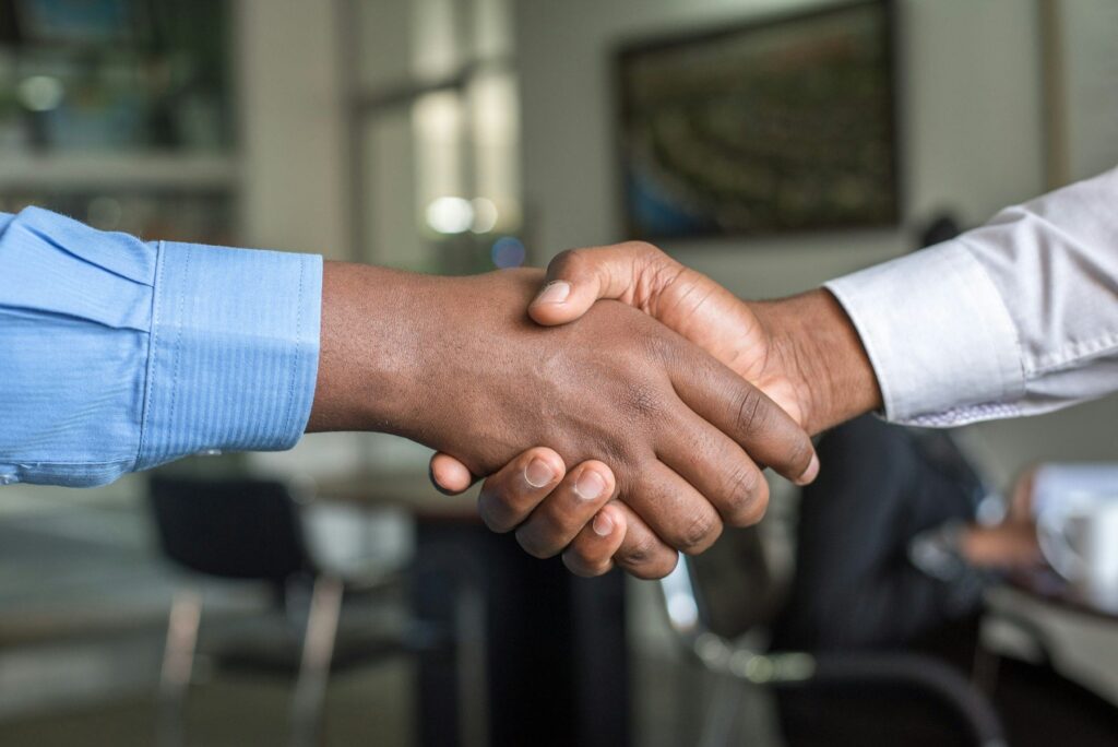 Two business partners shaking hands to confirm a trade agreement